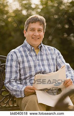 Stock Photo - Hispanic man reading newspaper. Fotosearch