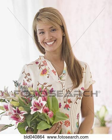 Picture - Hispanic woman holding bouquet of flowers. Fotosearch