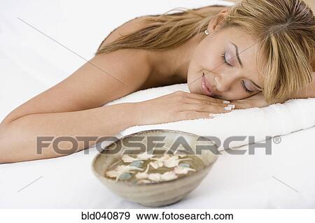Stock Photo - Hispanic woman laying on spa table. Fotosearch
