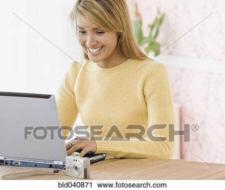 Stock Image - Hispanic woman typing on laptop. Fotosearch