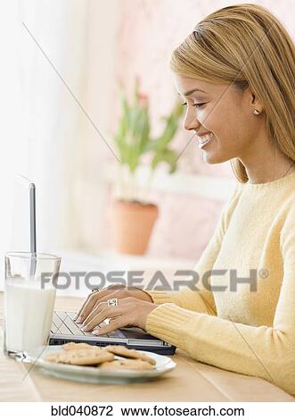 Hispanic woman typing on laptop View Large Photo Image Stock Image - Hispanic woman typing on laptop. Fotosearch