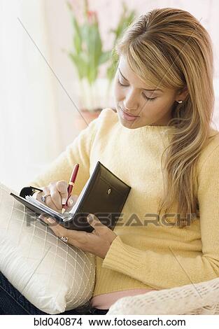 Hispanic woman writing in date book View Large Photo Image Picture - Hispanic woman writing in date book. Fotosearch