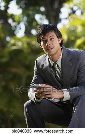 South American businessman sitting in park View Large Photo Image Stock Image - South American businessman sitting in park. Fotosearch