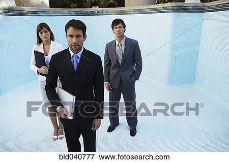 Stock Photo - South American businesspeople in empty swimming pool. Fotosearch