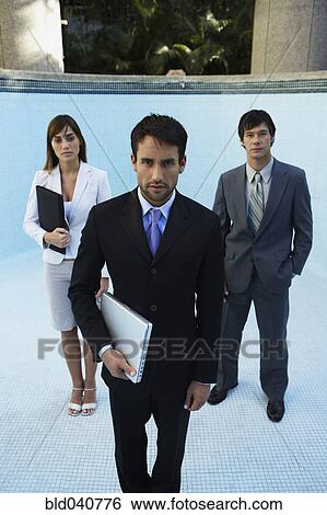 Stock Photograph - South American businesspeople in empty swimming pool. Fotosearch