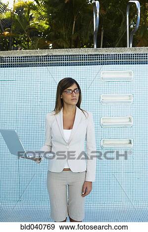 Stock Photo - South American businesswoman in empty swimming pool. Fotosearch