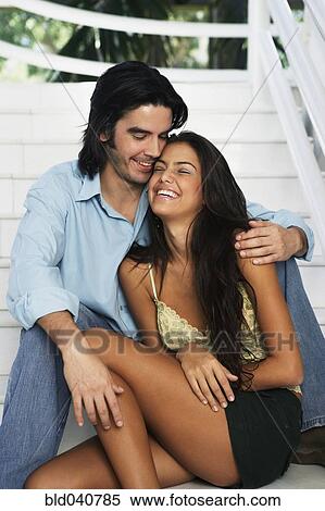 Stock Photography - South American couple hugging on stairs. Fotosearch
