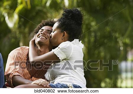 Stock Image - South American couple kissing in park. Fotosearch