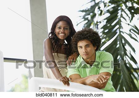 Stock Image - South American couple leaning on railing. Fotosearch