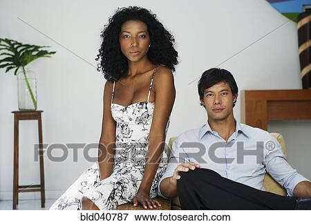 Stock Photo - South American couple sitting on chair. Fotosearch