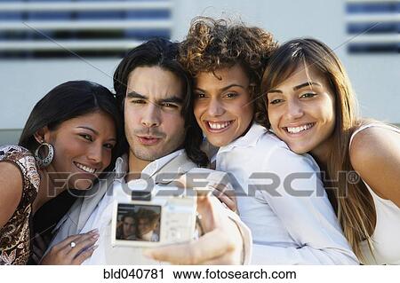 Stock Image - South American friends taking own photograph. Fotosearch