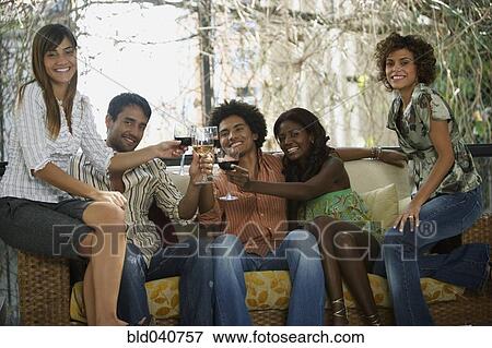 Stock Photo - South American friends toasting at party. Fotosearch