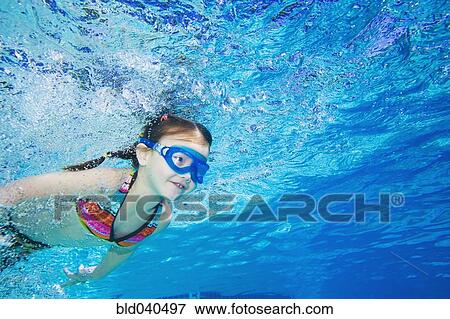 Stock Photo - Underwater shot of Asian girl swimming. Fotosearch