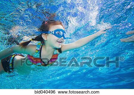 Stock Photograph - Underwater shot of Asian girl swimming. Fotosearch