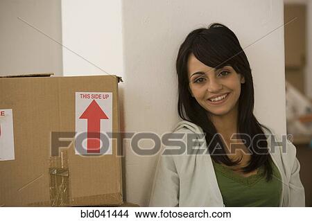 Woman sitting next to moving box View Large Photo Image Picture - Woman sitting next to moving box. Fotosearch