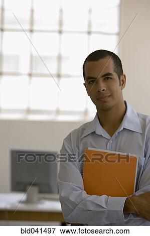 Young businessman holding notebook View Large Photo Image Stock Photo - Young businessman holding notebook. Fotosearch