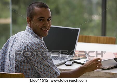 Stock Image - Young businessman working from home. Fotosearch