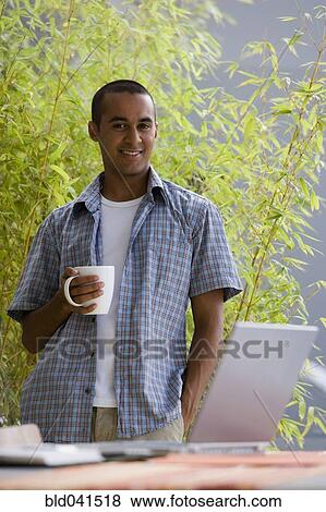 Stock Photo - Young businessman working from home. Fotosearch