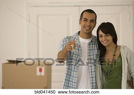 Stock Image - Young couple holding new house keys. Fotosearch
