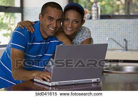 Stock Photography - Young couple hugging in kitchen. Fotosearch