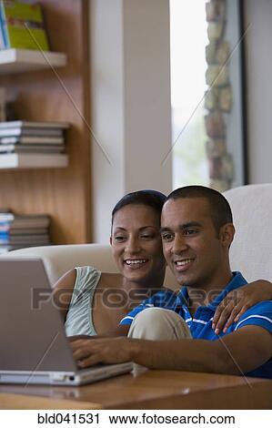 Stock Image - Young couple looking at laptop. Fotosearch
