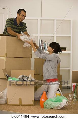 Young couple packing moving boxes View Large Photo Image Picture - Young couple packing moving boxes. Fotosearch
