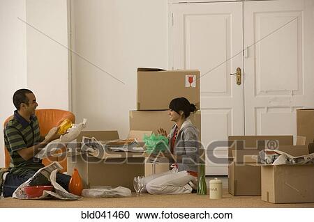 Stock Image - Young couple packing moving boxes. Fotosearch
