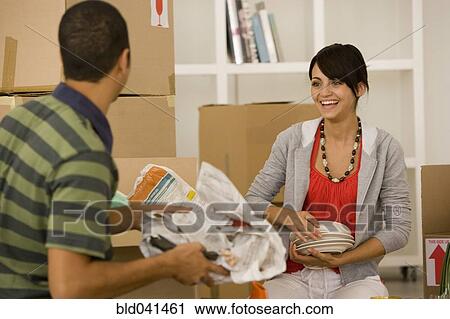 Young couple packing moving boxes View Large Photo Image Stock Image - Young couple packing moving boxes. Fotosearch