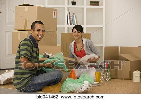 Stock Image - Young couple packing moving boxes. Fotosearch