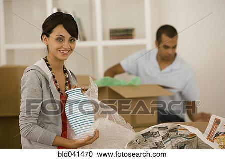 Stock Image - Young couple packing moving boxes. Fotosearch