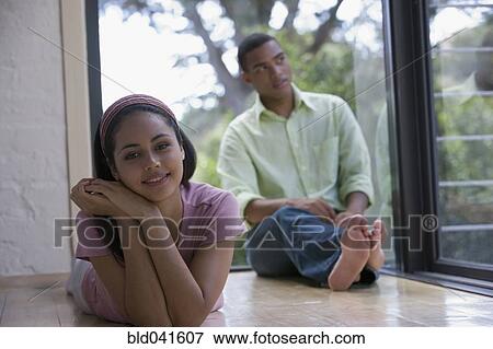 Young couple sitting on floor View Large Photo Image Stock Photo - Young couple sitting on floor. Fotosearch