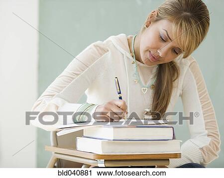 Young Hispanic woman writing at school desk View Large Photo Image Stock Image - Young Hispanic woman writing at school desk. Fotosearch