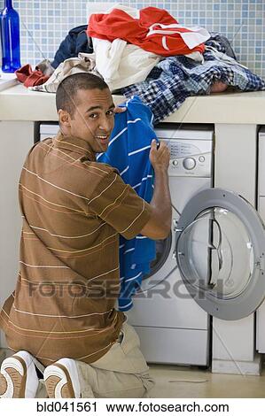 Young man doing laundry View Large Photo Image Stock Image - Young man doing laundry. Fotosearch