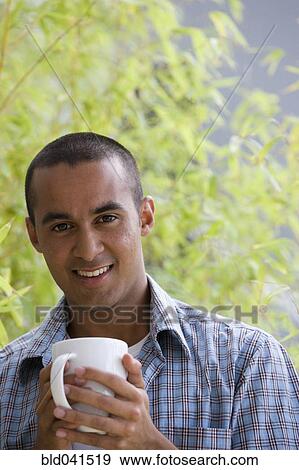 Young man drinking coffee View Large Photo Image Stock Photo - Young man drinking coffee. Fotosearch