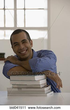 Young man leaning on books View Large Photo Image Stock Image - Young man leaning on books. Fotosearch