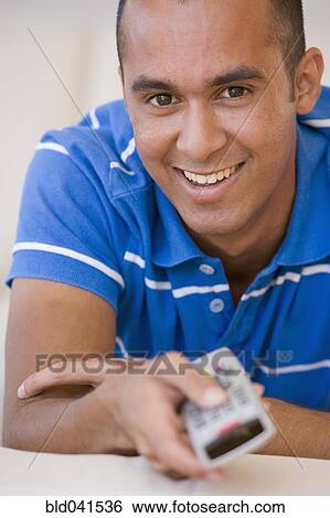 Young man pointing remote control View Large Photo Image Stock Photograph - Young man pointing remote control. Fotosearch