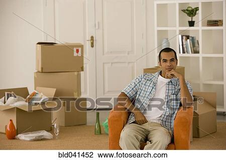 Young man sitting in new house View Large Photo Image Stock Image - Young man sitting in new house. Fotosearch