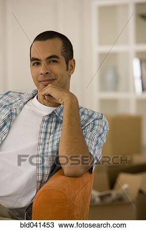 Young man sitting in new house View Large Photo Image Stock Image - Young man sitting in new house. Fotosearch