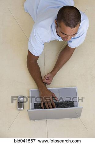 Stock Photo - Young man typing on laptop. Fotosearch