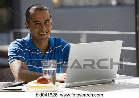 Young man typing on laptop View Large Photo Image Stock Photograph - Young man typing on laptop. Fotosearch