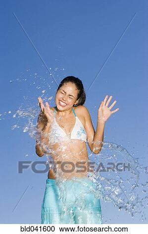 Young woman being splashed View Large Photo Image Stock Image - Young woman being splashed. Fotosearch