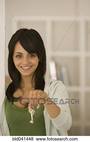 Young woman holding house key View Large Photo Image Stock Photo - Young woman holding house key. Fotosearch