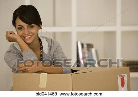 Young woman leaning on moving box View Large Photo Image Stock Photo - Young woman leaning on moving box. Fotosearch