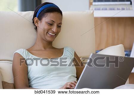 Young woman looking at laptop View Large Photo Image Stock Photo - Young woman looking at laptop. Fotosearch