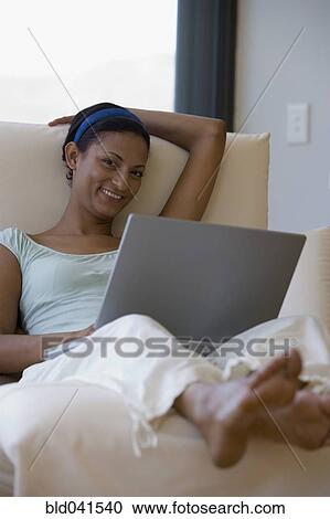 Young woman on chair with laptop View Large Photo Image Stock Image - Young woman on chair with laptop. Fotosearch