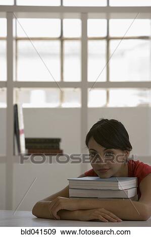 Young woman resting chin on books View Large Photo Image Stock Photo - Young woman resting chin on books. Fotosearch