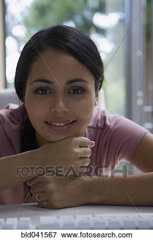 Young woman resting chin on fists View Large Photo Image Stock Photo - Young woman resting chin on fists. Fotosearch