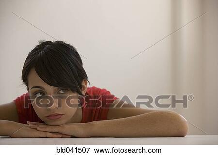 Stock Photo - Young woman resting chin on hands. Fotosearch
