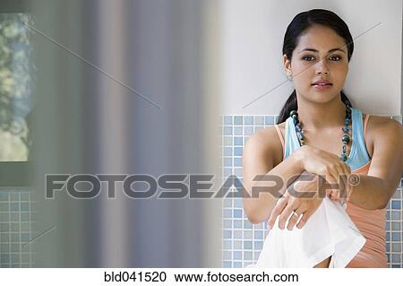 Young woman sitting against tile wall View Large Photo Image Stock Image - Young woman sitting against tile wall. Fotosearch