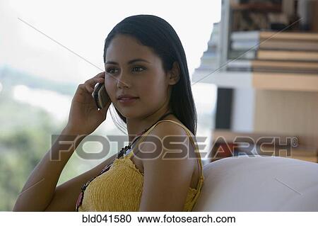 Stock Image - Young woman talking on cell phone. Fotosearch